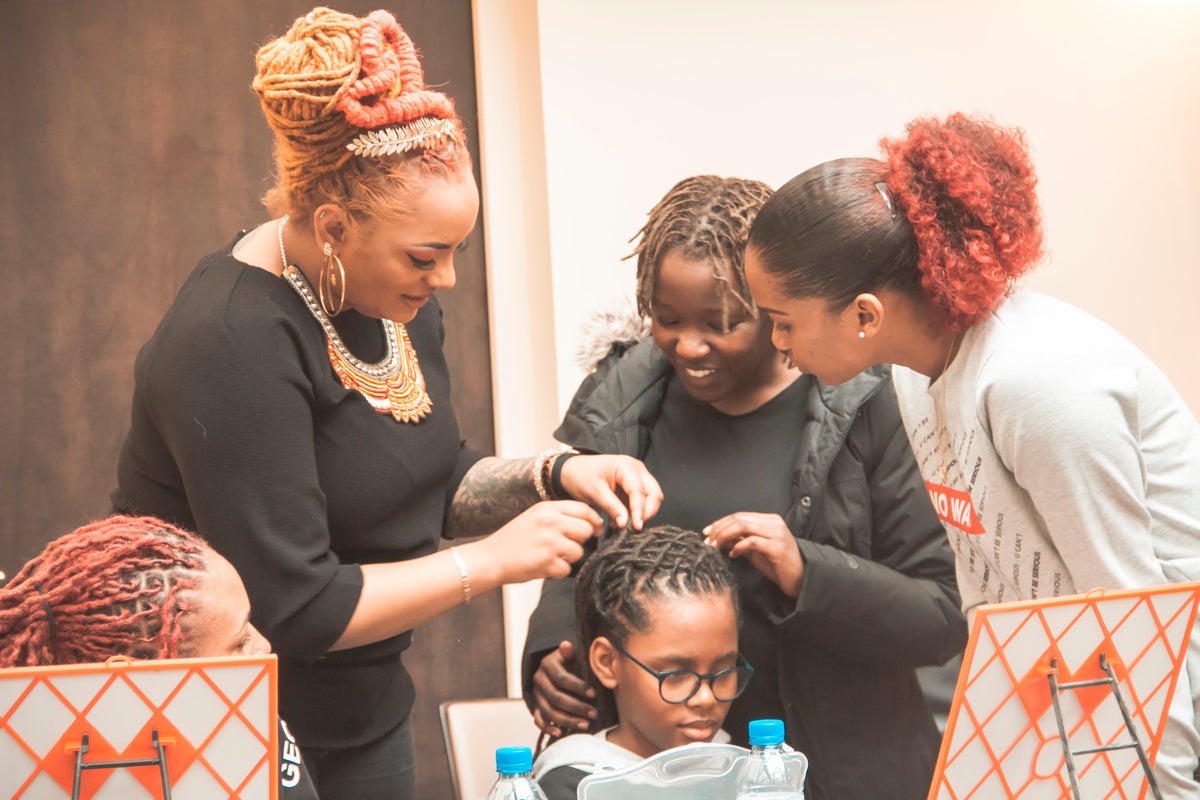 Formatrice entourée d'élèves pendant un atelier de coiffure DIY