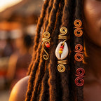Spirales dorées, cauris et perles colorées sur des Locks foncées en lumière chaude
