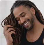 Homme souriant aux Locks coiffées en chignon, client Locks Passion