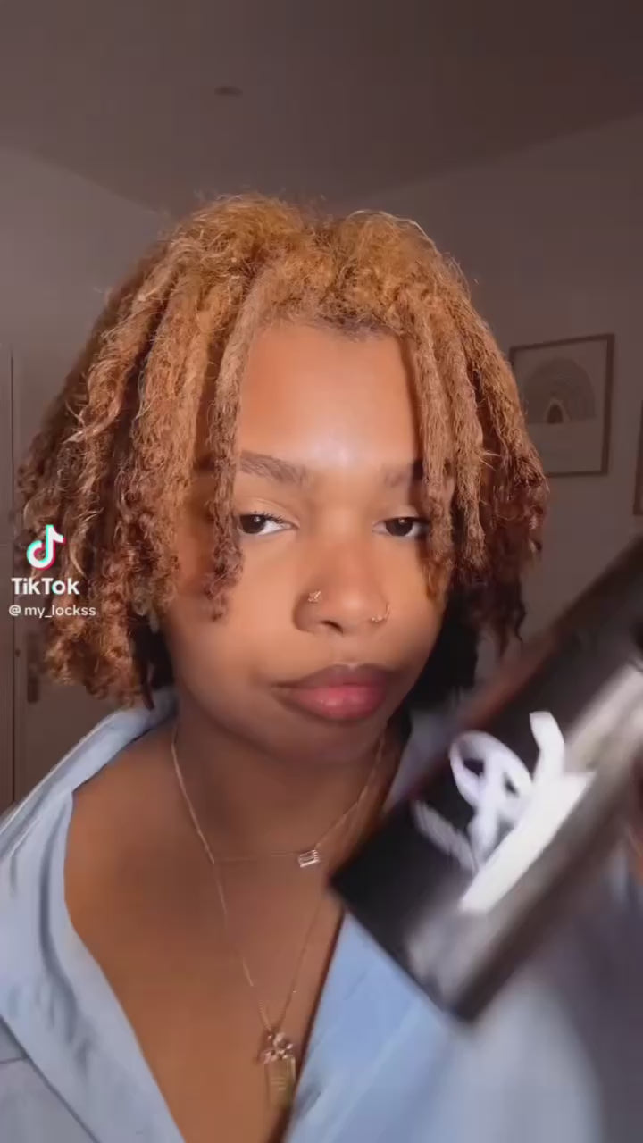 Femme fixant une pince sur sa coiffure de microlocks