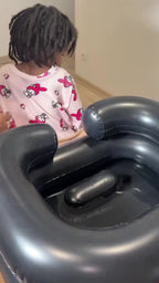 Lavage des cheveux d'un enfant dans un bac gonflable à domicile